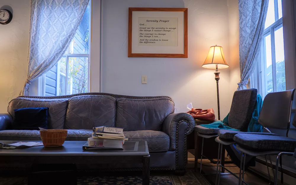12-step meeting room in Friday Harbor, Washington with comfortable couch, chairs, lamp, and serenity prayer framed on wall